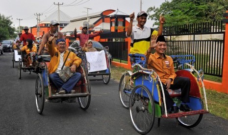 Sejumlah bakal calon legislatif (Bacaleg) Partai Hanura naik becak untuk mendaftar ke Kantor KPU Banten di Serang, Selasa (17/7).