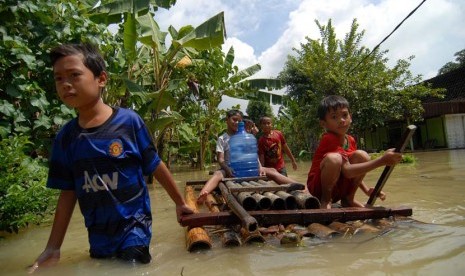  Sejumlah bocah membawa air mineral menggunakan rakit saat banjir menggenangi sejumlah daerah di Jawa Timur, Rabu (10/4). (Antara/Syaiful Arif)