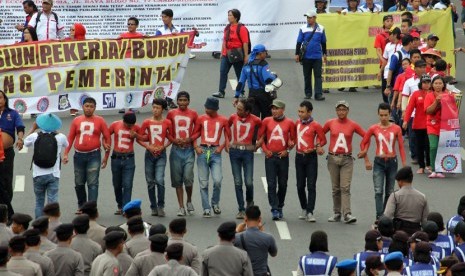 Sejumlah buruh dari Serikat Pekerja Nasional (SPN) berunjuk rasa di depan Gedung Negara Grahadi Surabaya, Jawa Timur, Kamis (30/4). (ANTARA/Didik Suhartono)