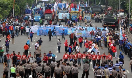 Sejumlah buruh dari Serikat Pekerja Nasional (SPN) berunjuk rasa di depan Gedung Negara Grahadi Surabaya, Jawa Timur, Kamis (30/4). (ANTARA/Didik Suhartono)