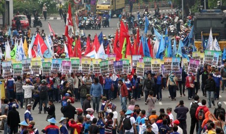 Sejumlah buruh dari Serikat Pekerja Nasional (SPN) berunjuk rasa di depan Gedung Negara Grahadi Surabaya, Jawa Timur, Kamis (30/4). (ANTARA/Didik Suhartono)