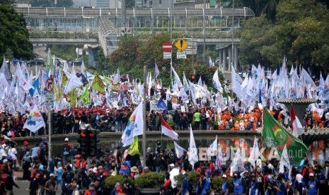 Sejumlah buruh menggelar aksi Hari Buruh Internasional di Jalan MH Thamrin, Jakarta, Pusat, Senin (1/5).