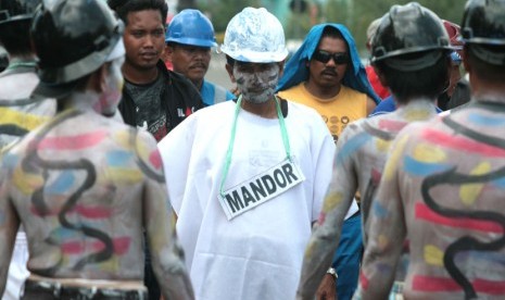 Sejumlah buruh yang tergabung dalam Konfederasi Kongres Aliansi serikat buruh Indonesia (KASBI) melakukan aksi teatrikal saat berunjukrasa di depan kantor Dinsosnaker, Indramayu, Jawa Barat, Senin (18/11).  (Antara/Dedhez Anggara)