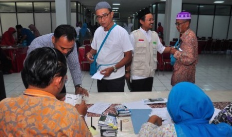 Sejumlah calon haji antre saat pembagian paspor di Embarkasi Haji Adisumarmo, Donohudan, Boyolali, Jawa Tengah, Sabtu (22/8). 