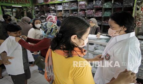 Sejumlah calon pembeli mencoba seragam sekolah. Pusat penjualan seragam sekolah kembali dipadati pembeli seiring kebijakan penerapan Pembelajaran Tatap Muka (PTM) 100 persen bagi PAUD, TK, SD dan SMP.