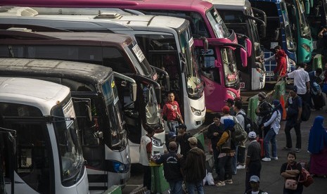 Sejumlah calon pemudik beraktivitas di depan bus di Terminal Kampung Rambutan, Jakarta, Rabu (13/6).