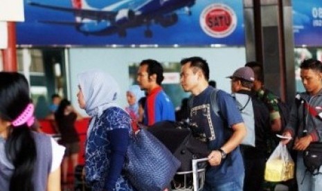 Sejumlah calon penumpang antre melewati pemeriksaan tiket di Terminal 1, Bandara Soekarno-Hatta, Cengkareng, Banten, Ahad (28/8). 