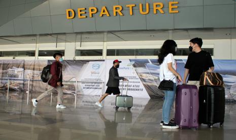 Sejumlah calon penumpang berjalan masuk ke dalam terminal keberangkatan di Bandara Internasional Sultan Hasanuddin, Maros, Sulawesi Selatan, Ahad (18/4/2021). 