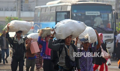 Sejumlah calon penumpang berjalan menuju bus untuk mengikuti Mudik Gratis bersama Pelindo III di Surabaya, Jawa Timur, Senin (11/6).