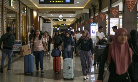 Sejumlah calon penumpang berjalan menuju terminal keberangkatan Bandara Adisutjipto, Sleman, DI Yogyakarta, Senin (24/12/2018).