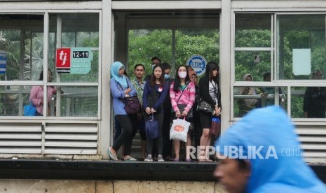 Sejumlah calon penumpang Bus Way Nampak menunggu datangnya Busway yang sedikit terhambat kedatangannya di halte bus way Kemayoran Landas Pacu Timur, Jakarta, Selasa (21/2).