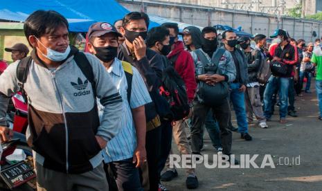 Sejumlah calon penumpang KRL Commuter Line antre hingga ke jalan raya di Stasiun Rangkasbitung, Lebak, Banten, Senin (8/6). Para calon penumpang KRL Commuter Line yang didominasi pekerja di Ibu kota tersebut terpaksa mengantre sejak dini hari akibat pembatasan penumpang dalam gerbong KRL.