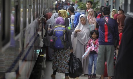 Sejumlah calon penumpang menaiki kereta api di Stasiun Pasar Senen, Jakarta, Jumat (14/4).