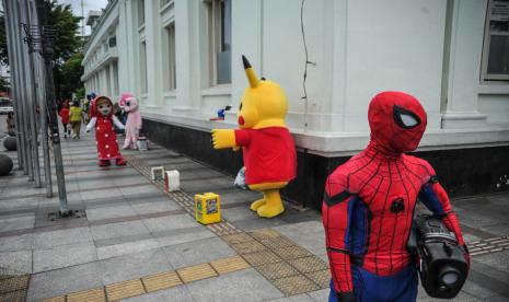 Sejumlah cosplayer berada di Jalan Asia Afrika, Bandung, Jawa Barat, Sabtu (5/3/2022). Pemerintah Kota Bandung tengah bersiap menuju perubahan dari pandemi COVID-19 ke endemi dengan salah satu cara yaitu melakukan percepatan vaksinasi yang hingga saat ini pencapaian vaksinasi dosis pertama sudah mencapai 112 persen, dosis kedua 100 persen dan dosis ketiga mencapai 15 persen.