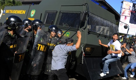 Sejumlah demonstran berusaha merusak kendaraan water canon aparat saat simulasi pengamanan hasil Pilpres di depan Gedung Sate, Bandung, Jawa Barat, Sabtu (19/7). 