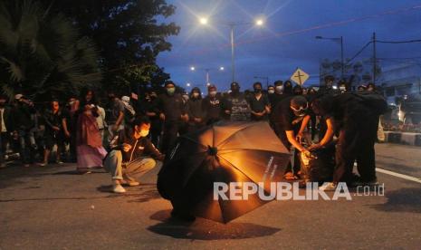 Sejumlah demonstran memblokade jalan sambil membakar ban saat aksi tolak Omnimbus Law di Jalan Khatib Sulaiman, Padang, Sumatera Barat, Jumat (9/10/2020). Demonstran yang mengatasnamakan Aksi Kamisan Padang itu berunjukrasa menolak pengesahan Undang-Undang Cipta Kerja atau Omnibus Law namun dibubarkan polisi karena memblokade jalan protokol dan sudah melewati batas waktu yang ditentukan.