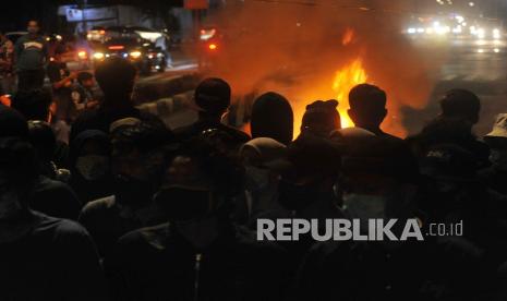 Sejumlah demonstran memblokade jalan sambil membakar ban saat aksi tolak Omnimbus Law di Jalan Khatib Sulaiman, Padang, Sumatera Barat, Jumat (9/10/2020). Demonstran yang mengatasnamakan Aksi Kamisan Padang itu berunjukrasa menolak pengesahan Undang-Undang Cipta Kerja atau Omnibus Law namun dibubarkan polisi karena memblokade jalan protokol dan sudah melewati batas waktu yang ditentukan.