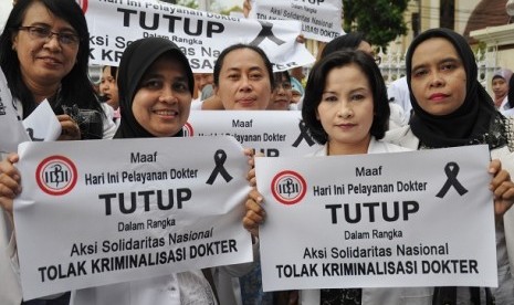 Sejumlah dokter membawa poster saat melakukan aksi solidaritas di depan Rumah Sakit Umum provinsi NTB di Mataram, Rabu (27/11). 