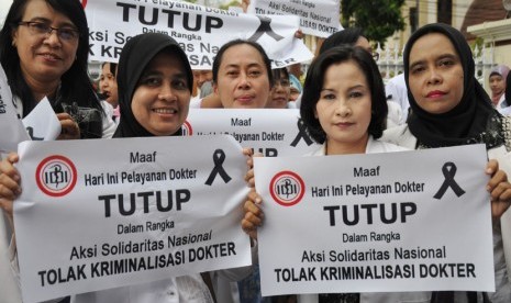 Sejumlah dokter membawa poster saat melakukan aksi solidaritas di depan Rumah Sakit Umum provinsi NTB di Mataram, Rabu (27/11).  (Antara/Ahmad Subaidi)