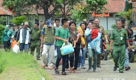 Sejumlah eks Gafatar berjalan menuju bis untuk pulang kampung.