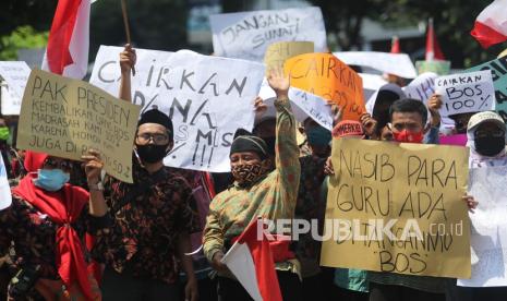 Sejumlah guru dan Kepala Madrasah swasta se-Kediri membentangkan poster saat unjuk rasa di kantor Kementerian Agama di Kediri, Jawa Timur, Kamis (5/11/2020). Para pengunjuk rasa menolak pemotongan dana Bantuan Operasional Sekolah (Bos) hingga 50 persen yang mengakibatkan proses pembelajaran tidak bisa maksimal karena keterbatasan anggaran milik sekolah.