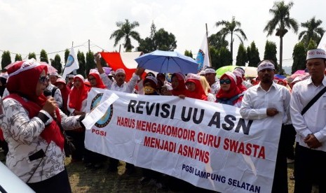 Sejumlah guru honor sekolah swasta tergabung dalam Persatuan Guru Selolah Indonesia Lampung menggelar aksi damai di depan gedung DPRD Lampung, Senin (30/4).