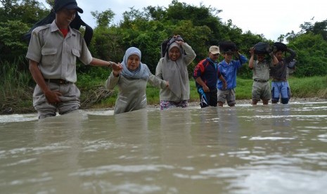 Sejumlah guru SDN Pojok Klitih III bergandengan tangan ketika melewati sungai saat berangkat mengajar di desa terpencil, Kabupaten Jombang, Jawa Timur. (Ilustrasi)