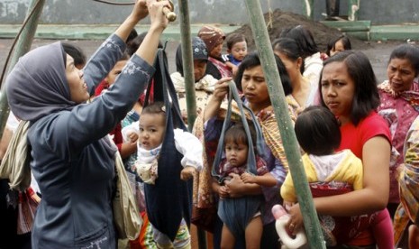 ibu-ibu antre menimbang bayi di posyandu