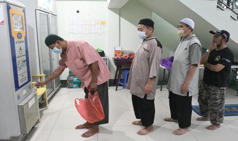 Sejumlah jamaah antre untuk mengakses ATM beras di Masjid Baitul Makmuur, di Desa Telaga Murni, Cikarang Barat, Jumat (22/4/2022). Program ATM beras tersebut untuk membantu 300 jamaah yang tidak mampu dengan total 12 liter per orang untuk satu bulan