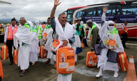 Sejumlah Jamaah calon haji kloter pertama Embarkasi Aceh melambaikan tangan sebelum naik ke pesawat udara di Bandara internasional Sultan Iskandar Muda, Aceh Besar, Aceh, Sabtu (20/7/2019). 