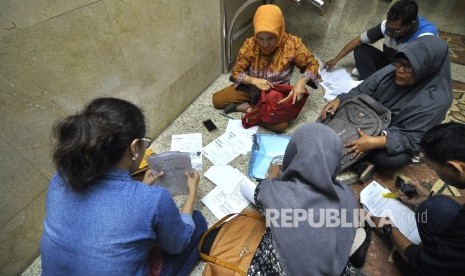 Sejumlah jamaah korban dugaan penipuan perjalan umrah First Travel mengisi formulis pengaduan di Kantor Bareskrim Polri Gambir, Jakarta Pusat, Selasa (22/8).