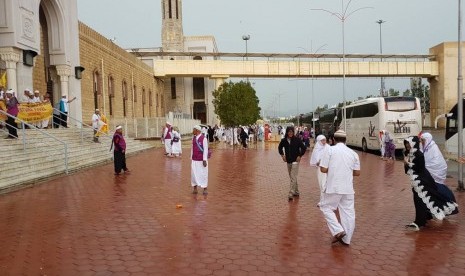 Sejumlah jamaah umrah asal Indonesia menikmati sejuknya jalan-jalan Makkah usai diguyur hujan, Sabtu (29/4).