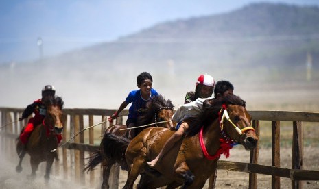   Sejumlah joki cilik memacu kuda mereka saat gelaran Pacuan Kuda Tradisional (Main Jaran)  di kawasan Penyaring, Moyo Utara, Sumbawa, NTB, Ahad (11/11). (Antara/Ismar Patrizki)