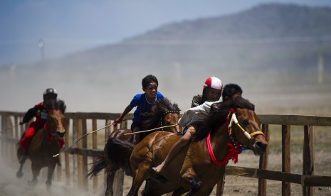 Sejumlah joki cilik memacu kuda mereka saat gelaran Pacuan Kuda Tradisional (Main Jaran) di arena pacu kuda di kawasan Penyaring, Moyo Utara, Sumbawa, NTB, Ahad (11/11).