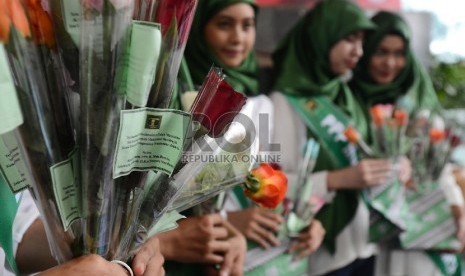   Sejumlah Kader Perempuan Muda Partai Persatuan Pembangunan (PPP) memberikan bunga kepada karyawan Kementerian Hukum dan HAM saat melakukan aksi damai di Gedung Kemenkumham, Jakarta, Senin (11/1). (Republika/Raisan Al Farisi)