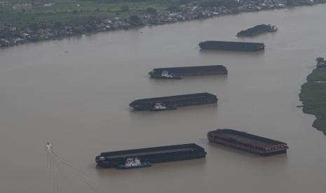 Sejumlah kapal tongkang pengangkut batu bara melintas di Sungai Musi, Palembang, Sumatera Selatan. Asosiasi Perusahaan Batubara Indonesia (APBI) berkomitmen untuk tetap mendukung program Domestic Market Obligation (DMO). Langkah ini dilakukan untuk menjaga pasokan listrik di Indonesia.