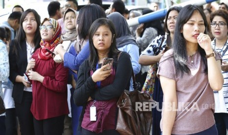 Sejumlah karyawan berkumpul di luar gedung pasca gempa yang mengguncang Jakarta, Selasa (23/1).