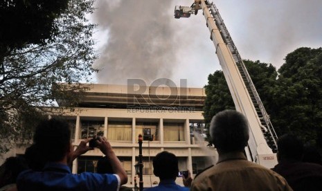  Sejumlah karyawan Istana Negara menyaksikan petugas memadamkan api kebakaran lantai tiga Gedung Sekretariat Negara di Kompleks Istana Negara, Jakarta, Kamis (21/3) sore. (Republika/Aditya Pradana Putra)