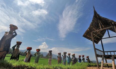 Sejumlah kaum ibu menggunakan masker, membawa baki di kepala mereka, saat digelarnya Festival Budaya Batipuh, di Batang Gadih, Nagari Batipuh Baruah, Kec.Batipuh, Kab.Tanah Datar, Sumatera Barat, Sabtu (15/8/2020). Festival budaya tersebut digelar dengan tetap mematuhi protokol COVID-19. 