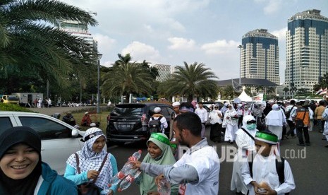 Sejumlah kelompok masyarakat membagikan minuman gratis pada peserta Aksi Indonesia Bebaskan Alquds, di Monas. Jumat (11/5). 