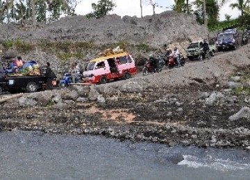 Sejumlah kendaraan antre menyeberang jembatan bambu darurat di atas sungai Pabelan desa Tlatar, Sawangan, Magelang, Jateng, Senin (22/8). Jembatan tersebut merupakan jembatan darurat di jalur mudik terdekat pengganti jembatan Tlatar yang ambrol diterjang b