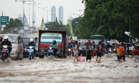 Sejumlah kendaraan berjalan perlahan terhambat oleh air luapan Sungai Ciliwung di Jalan Jatinegara Barat, Jakarta Timur, Kamis (20/11). 