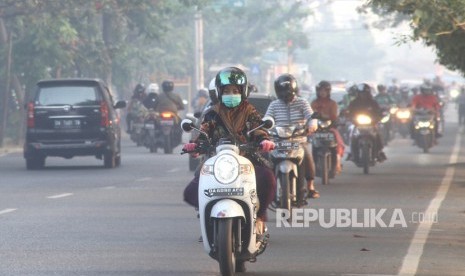 Sejumlah kendaraan bermotor melaju menembus kabut asap 