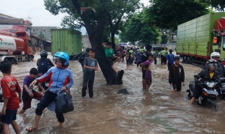 Sejumlah kendaraan dan pejalan kaki berusaha melintasi banjir di depan Pabrik Kahatex kawasan Rancaekek, Kabupaten Bandung, Jawa Barat, Selasa (1/11).