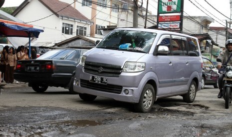  Sejumlah kendaraan melaju dengan perlahan saat melintasi jalan berlubang.  (foto : MgROL_37)