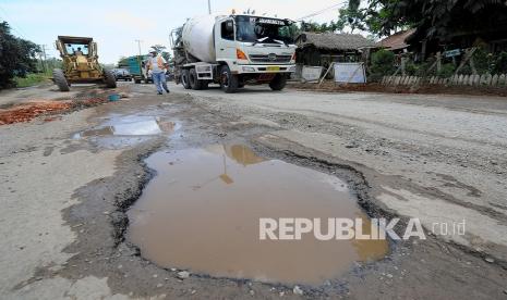 Sejumlah kendaraan melaju pelan saat melintasi Jalan Lintas Sumatera yang rusak di Mestong, Muarojambi, Jambi, Senin (7/3/2022). Jalan nasional penghubung Jambi dengan Sumatera Selatan tersebut rusak di sejumlah titik sehingga membahayakan keselamatan pengendara. 