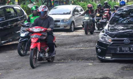 Sejumlah kendaraan melewati jalan rusak di jalan I Gusti Ngurah Rai, Bekasi, Jawa Barat.