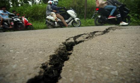 Sejumlah kendaraan melintas di jalan raya yang retak karena pergerakan tanah yang berada di kaki Gunung Slamet. Badan Geologi Kementerian ESDM sebut aktivitas gempa dari Gunung Slamet meningkat.