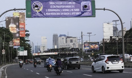 Sejumlah kendaraan melintas dibawa papan pemberitahuan Uji Coba Penghapusan Kawasan 3in1 di kawasan Jalan Gatot Subroto, Jakarta, Minggu (3/4).ANTARA FOTO/Muhammad Adimaja