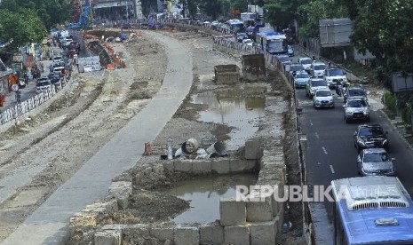 Sejumlah kendaraan melintas disamping proyek pembangunan underpass masih dalam proses penyelesaian di Kawasan Mampang, Jakarta Selatan, Senin (3/7). 